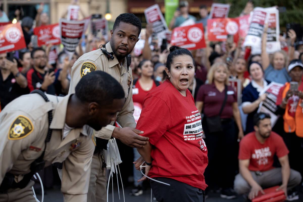 A culinary union member continues to chant while she is arrested during a rally along Las Vegas ...