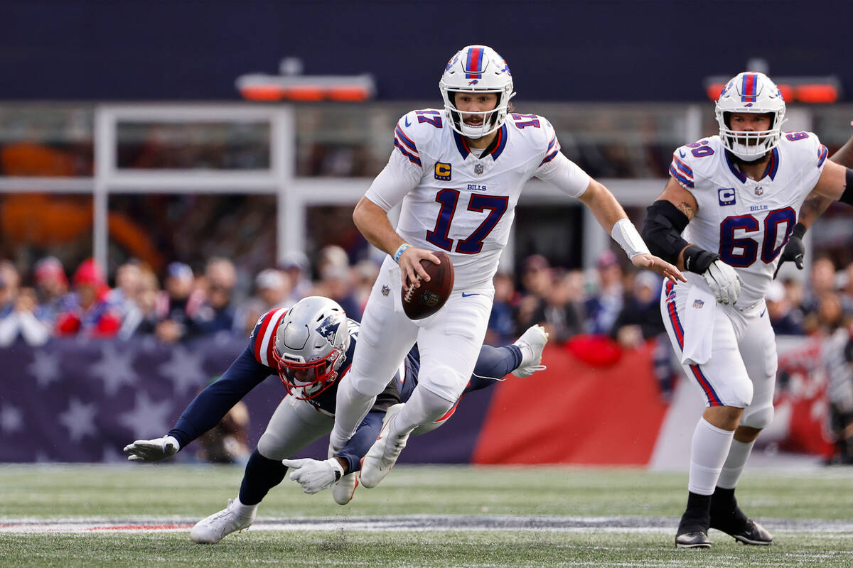 Buffalo Bills quarterback Josh Allen gets tripped up while running by New England Patriots line ...