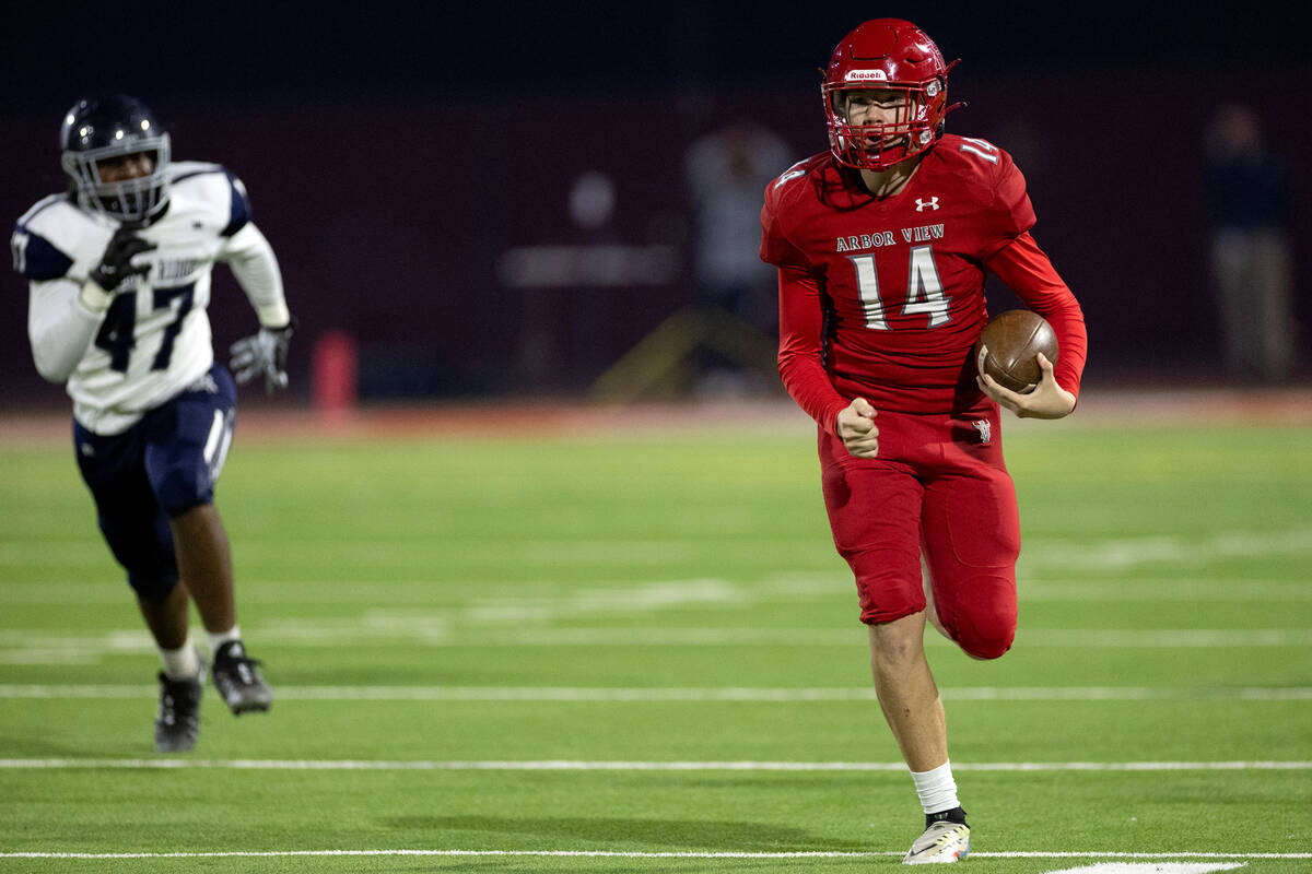 Arbor View quarterback Alonzo Balderrama (14) keeps the ball while Shadow Ridge defensive end E ...