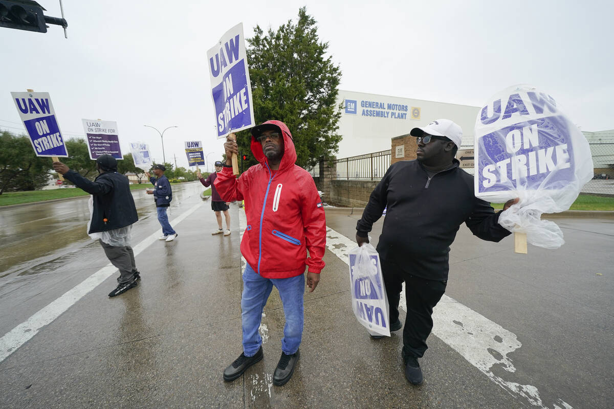 File - Picketers strike outside of the General Motors assembly plant, Tuesday, Oct. 24, 2023, i ...