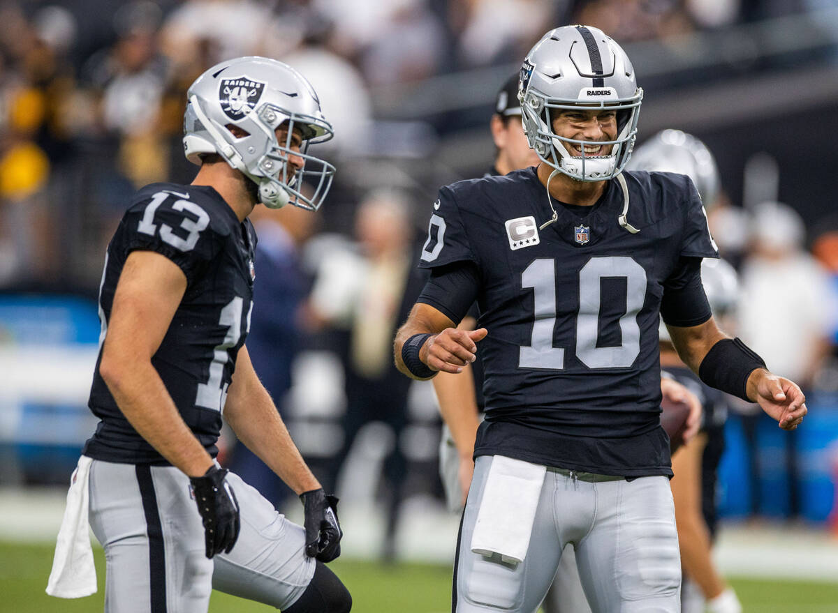 Raiders quarterback Jimmy Garoppolo (10) shares a laugh with receiver Hunter Renfrow (13) durin ...