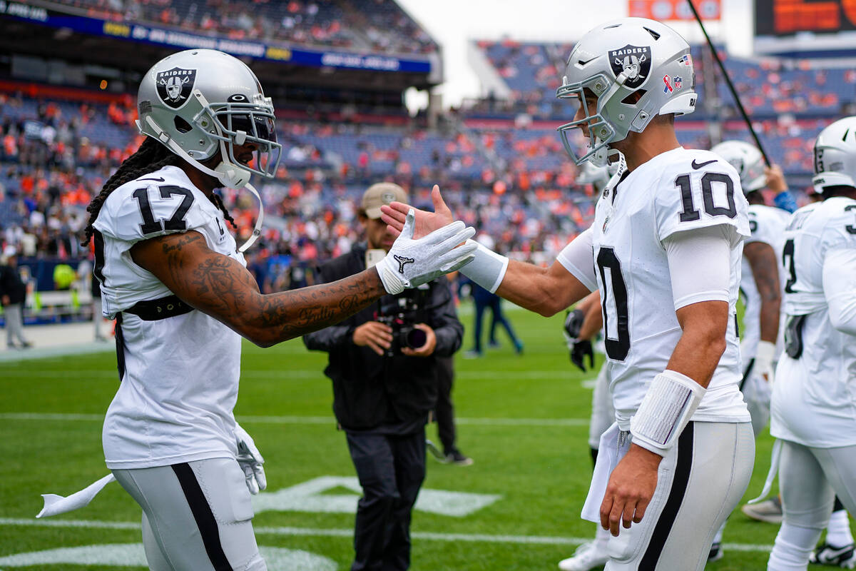 Las Vegas Raiders quarterback Jimmy Garoppolo (10 and wide receiver Davante Adams (17) warm up ...