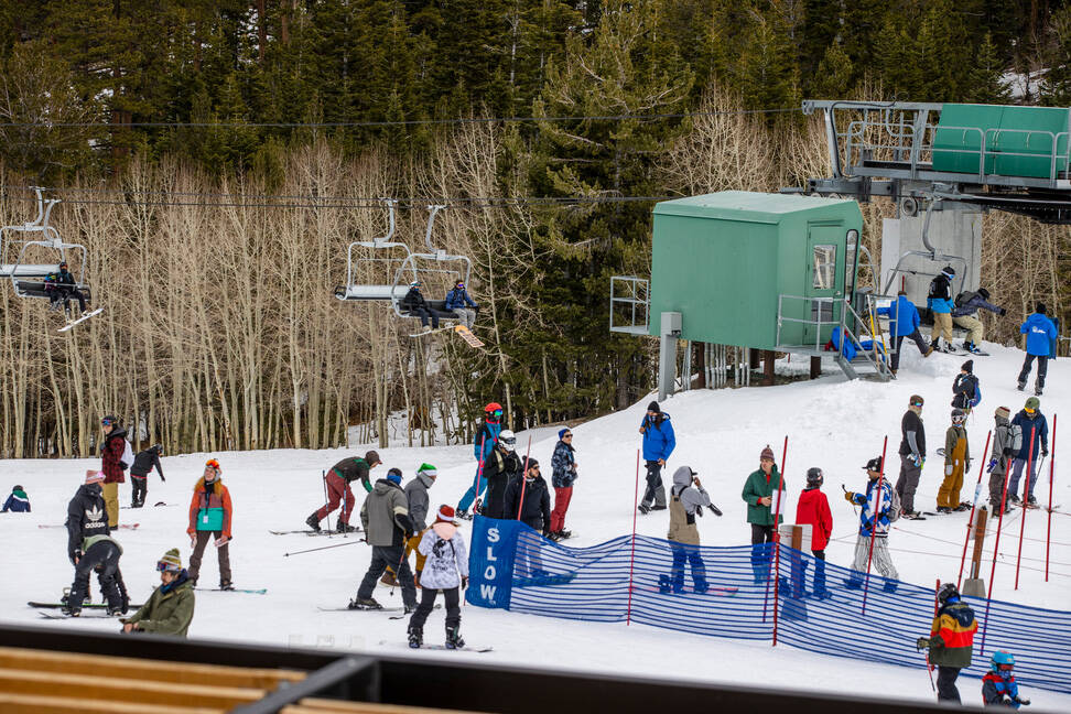 People move about the bottom of a run near the lift during opening day of skiing and snowboardi ...