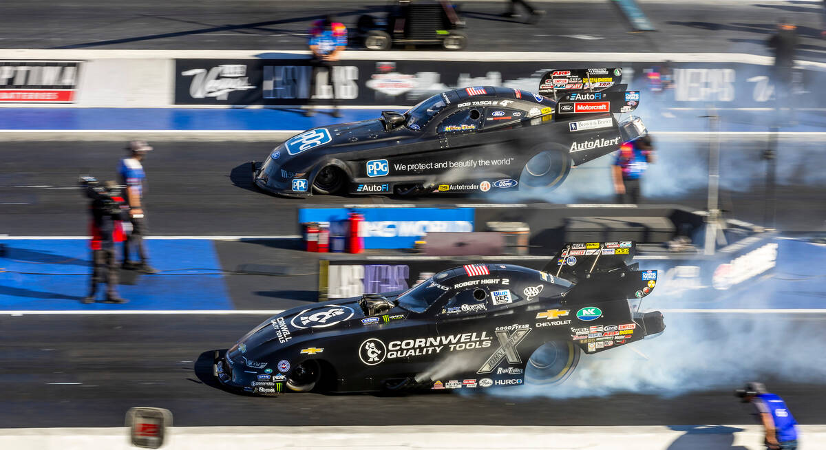 Bob Tasca III, top, and Robert Hight burn their tires during a Funny Car qualifying session in ...