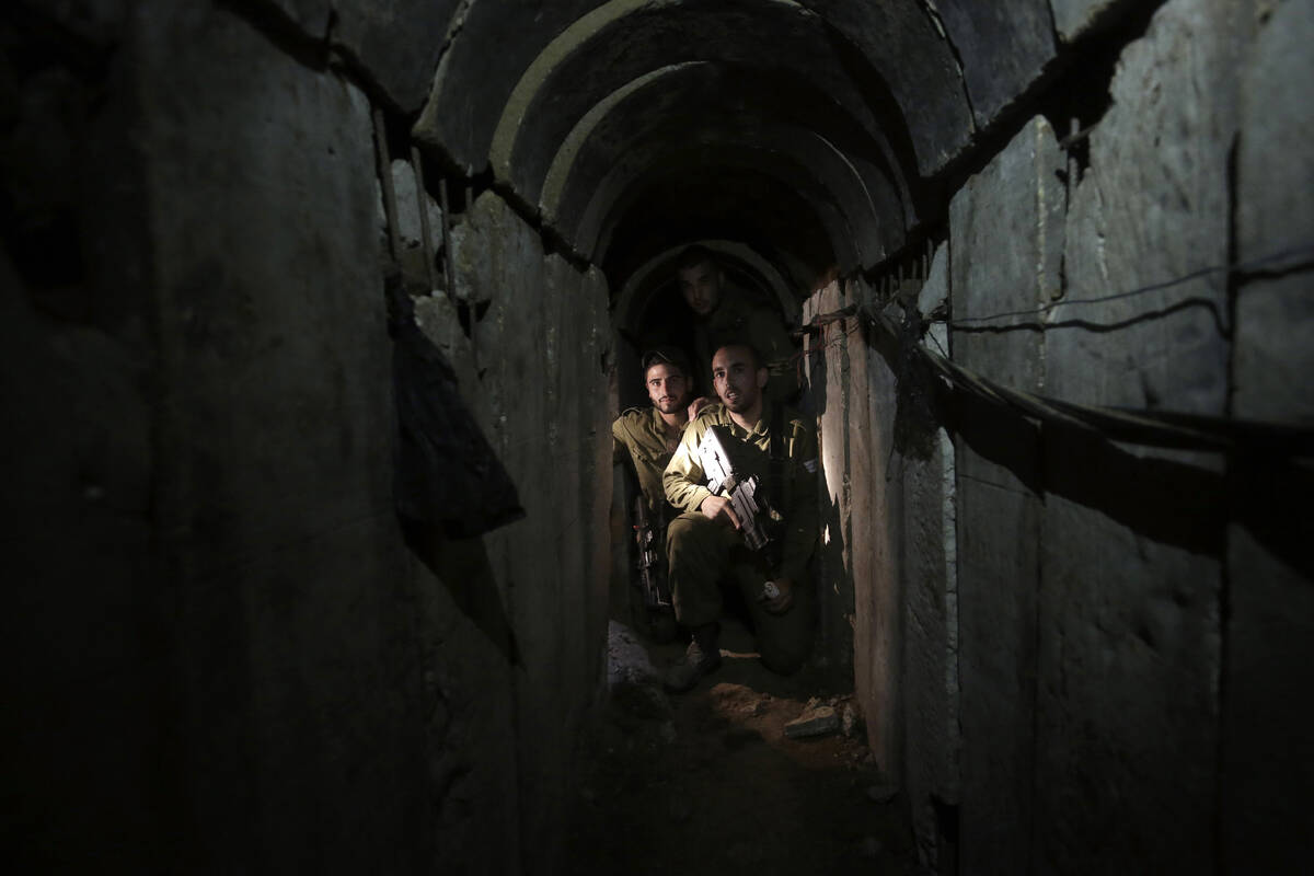 FILE - Israeli soldiers walk through a tunnel discovered near the Israel-Gaza border Sunday, Oc ...