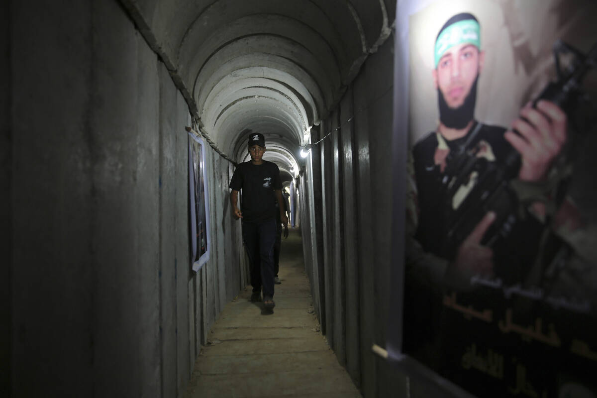 FILE - A Palestinian youth walks inside a tunnel used for military exercises during a weapon ex ...