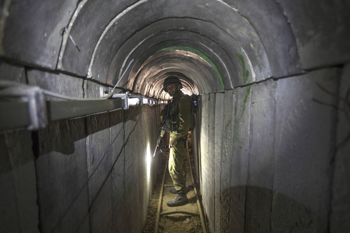 FILE - An Israeli army officer gives journalists a tour of a tunnel allegedly used by Palestini ...