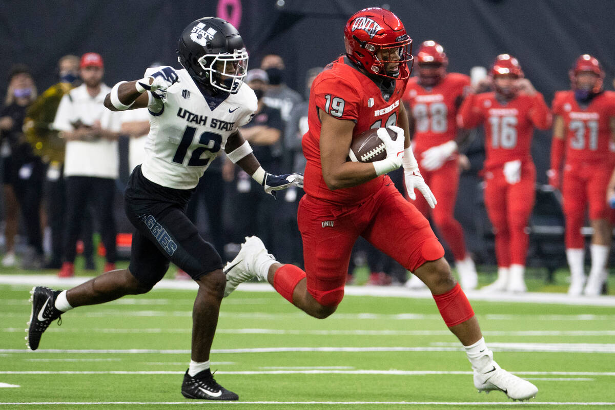 UNLV Rebels tight end Kaleo Ballungay (19) breaks off a big run past Utah State Aggies safety A ...