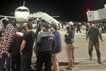 People in the crowd walk shouting antisemitic slogans at an airfield of the airport in Makhachk ...