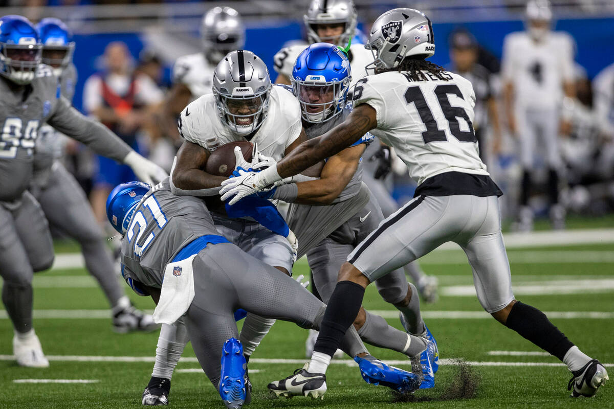 Raiders running back Josh Jacobs (8) pushes for more yards as Detroit Lions safety Tracy Walker ...