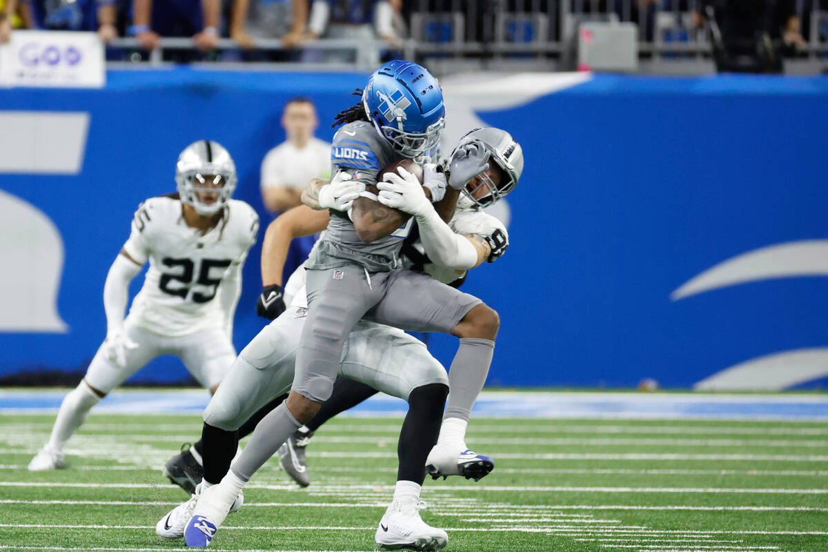 Detroit Lions wide receiver Jameson Williams (9) is tackled by Las Vegas Raiders defensive end ...