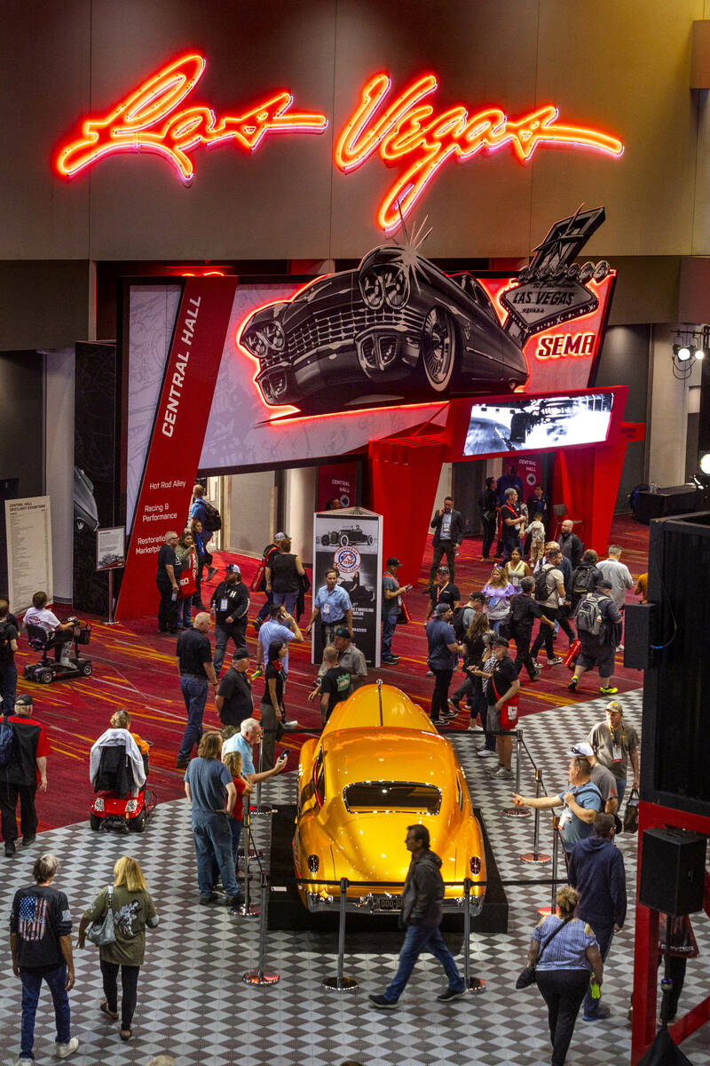 Attendees check out a classic car at the Central Hall entrance during the first day of SEMA at ...