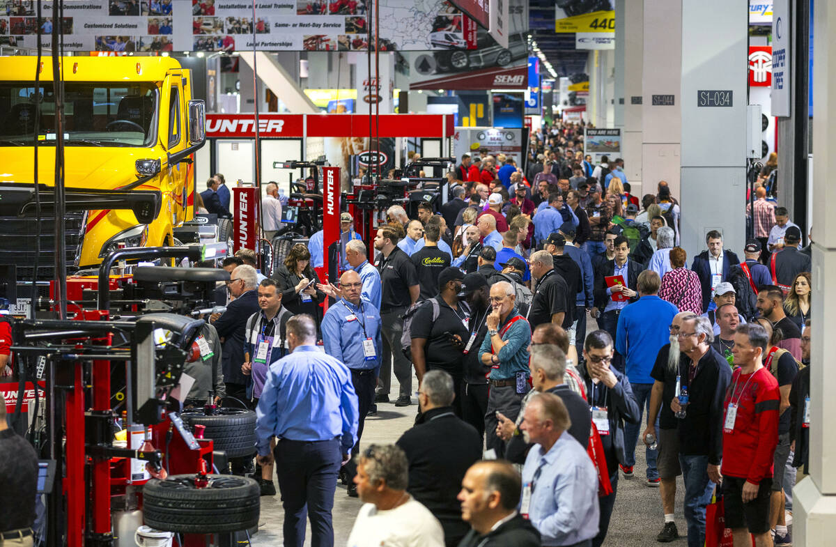Attendees walk about and view some of the many vehicle maintenance machines on display during t ...
