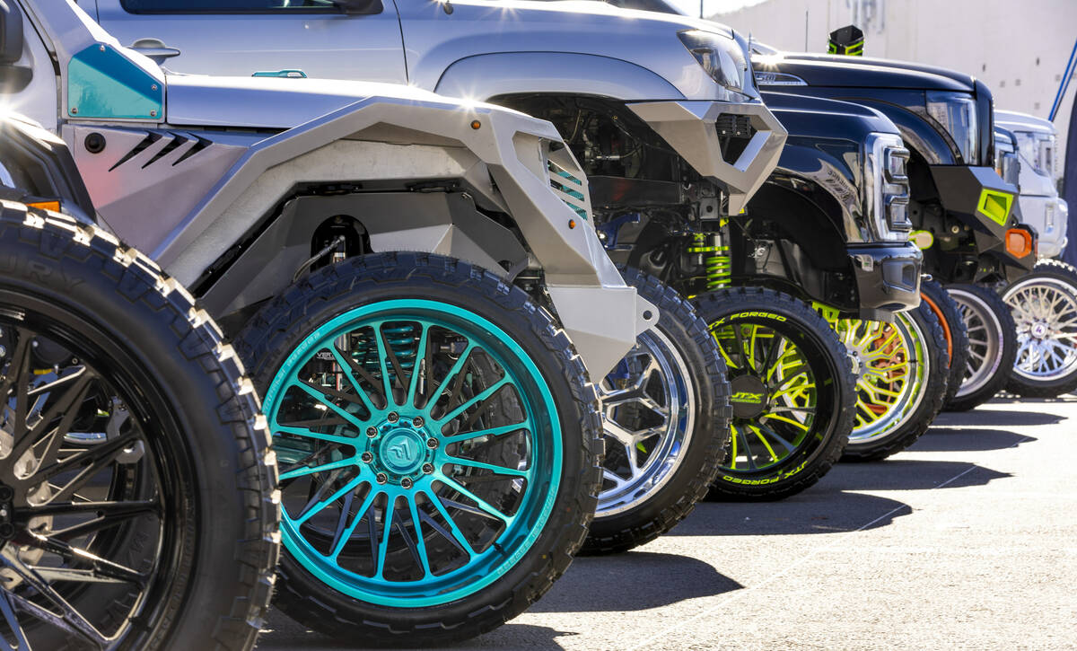 A colorful display of metal rims are on vehicles outside during the first day of SEMA at the La ...