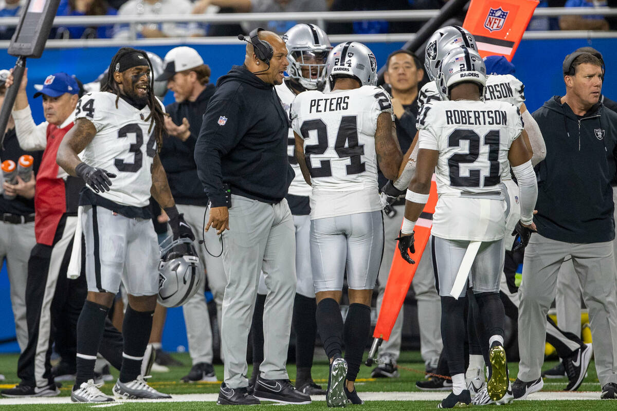 Raiders linebacker coach Antonio Pierce and running back Brandon Bolden (34) congratulate corne ...