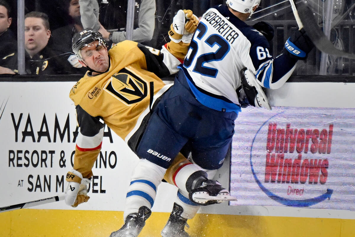 Vegas Golden Knights defenseman Alec Martinez, left, is checked by Winnipeg Jets right wing Nin ...