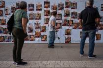 People look at photographs of hostages. mostly Israeli civilians who were abducted during the O ...