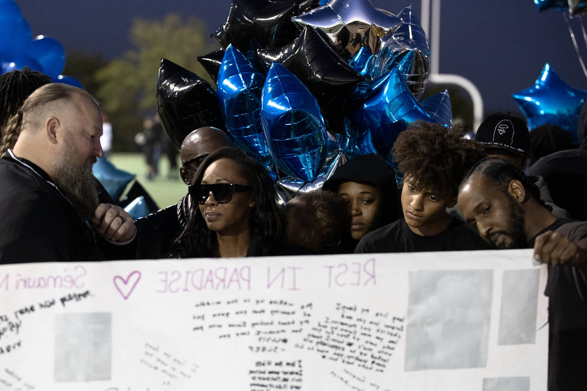 Maureisha Johnson views a signed poster in honor of her son, Desert Pines High School football ...
