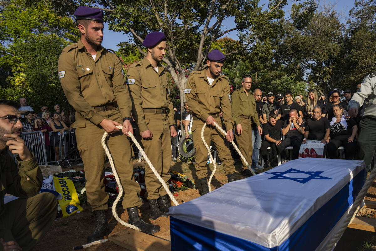 Israeli soldiers lower the coffin of late Israeli Staff Sergeant Shay Arvas at the Holon milita ...