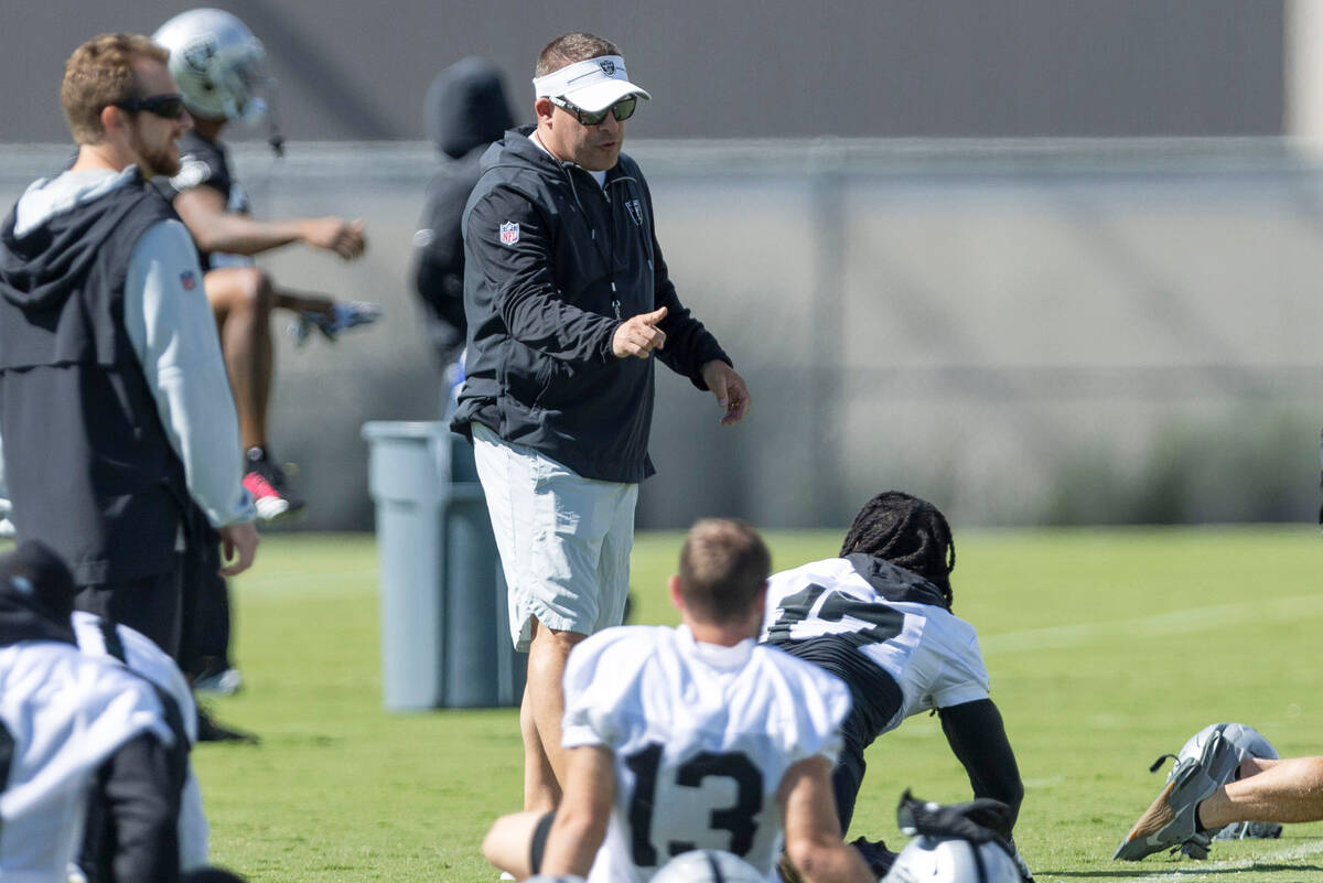 Raiders head coach Josh McDaniels speaks with wide receiver Davante Adams (17) during team prac ...