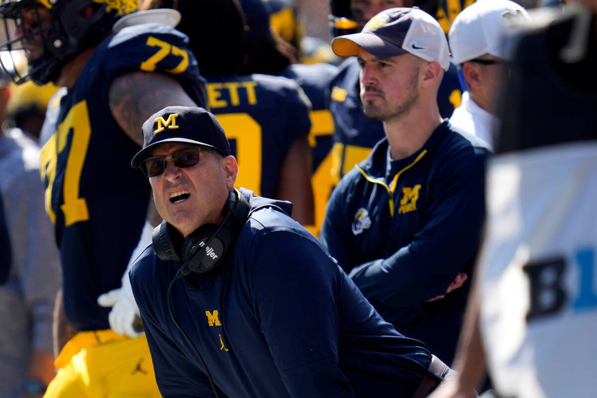 Michigan head coach Jim Harbaugh, front left, watches against Rutgers as analytics assistant Co ...
