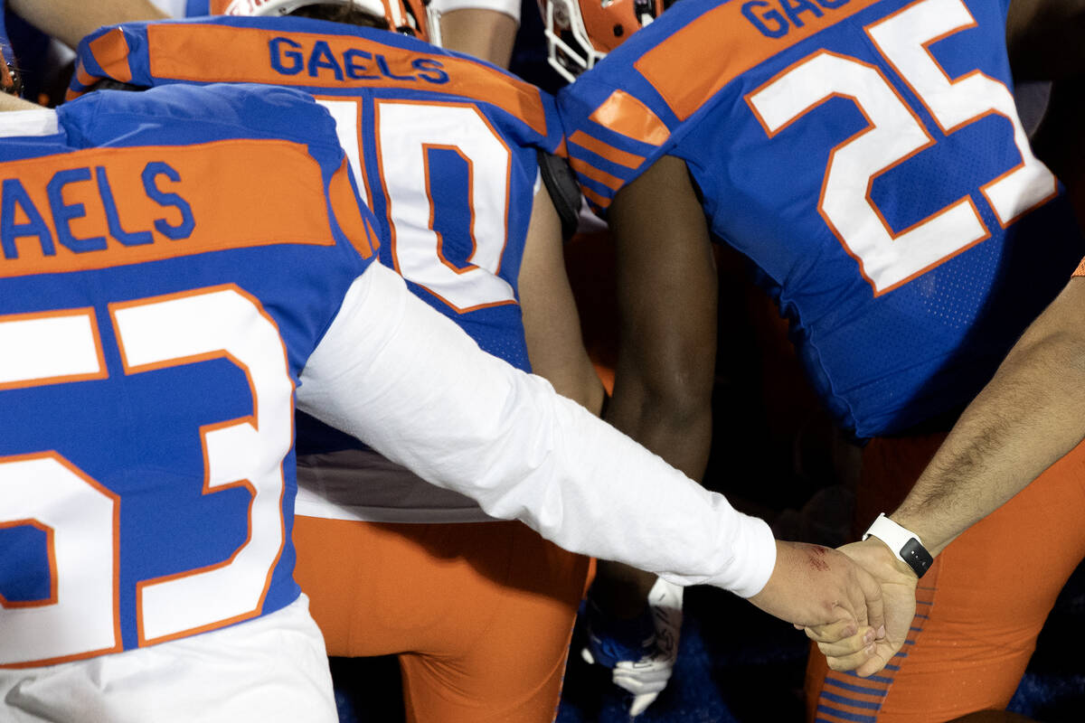 Bishop Gorman players hold hands in prayer after winning a Class 5A Division I state semifinal ...