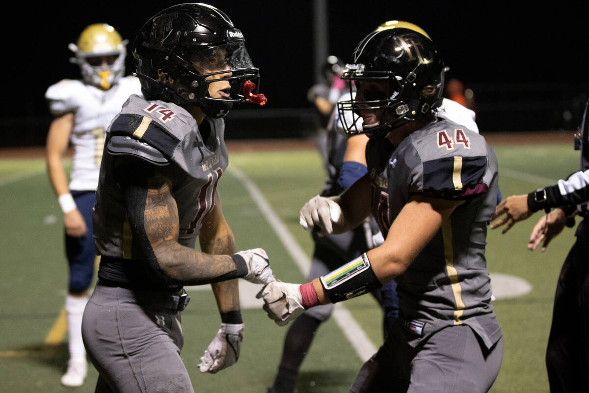 Faith Lutheran running back Cale Breslin (14) celebrates with fullback Mitchell Bailes (44) aft ...