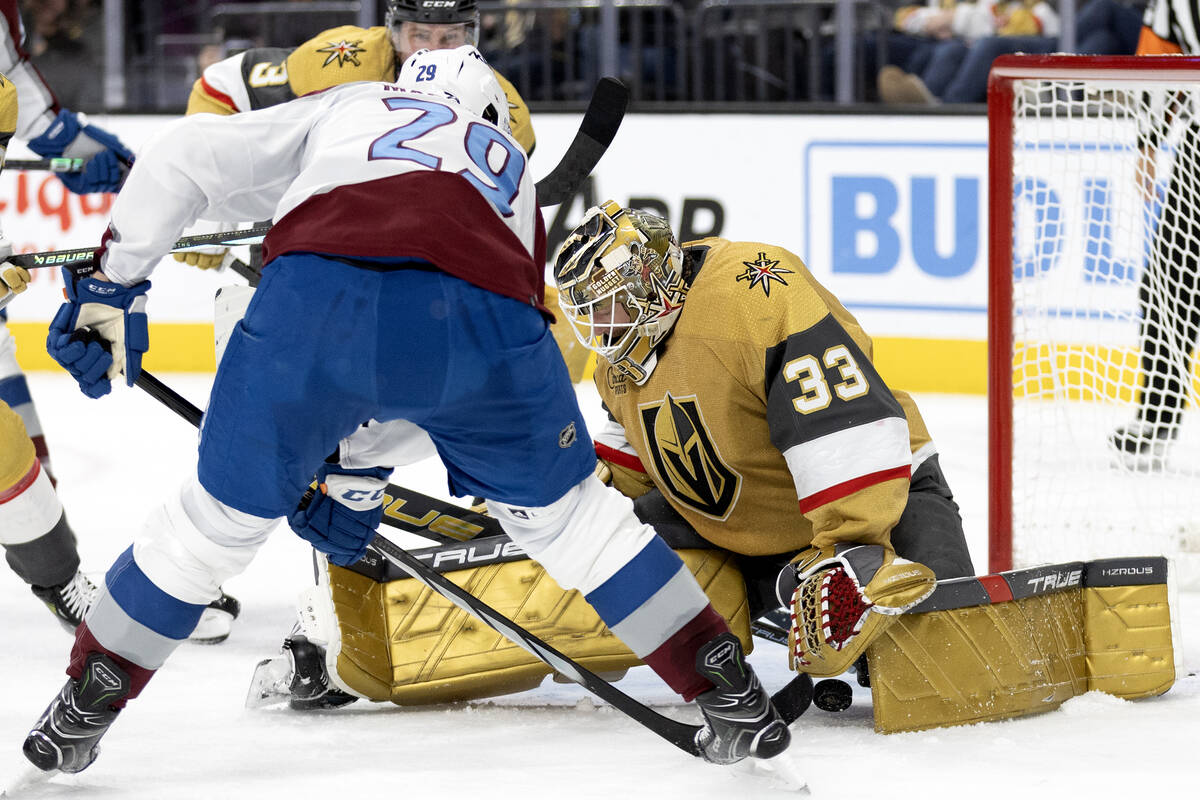 Golden Knights goaltender Adin Hill (33) works to save the puck against Avalanche center Nathan ...
