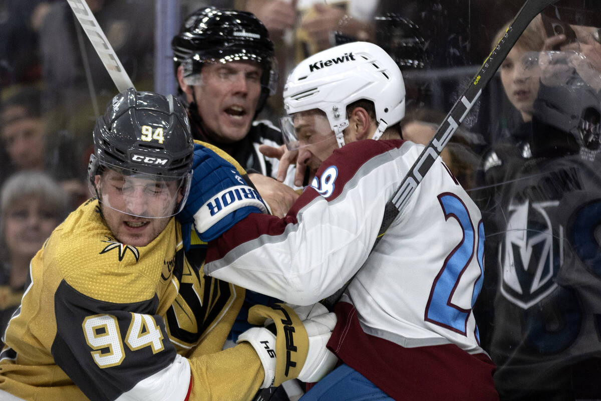 Golden Knights defenseman Brayden Pachal (94) fights with Avalanche left wing Miles Wood (28) d ...