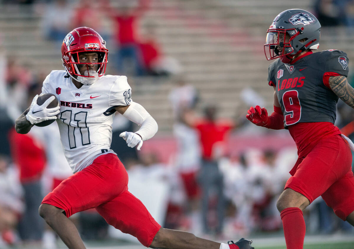 UNLV's Ricky White, left, looks back at New Mexico's Noa Pola-Gates, right, while running a rec ...