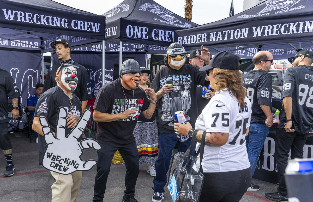 Raiders fans and characters dance in the tailgating area before the start of the Raiders agains ...