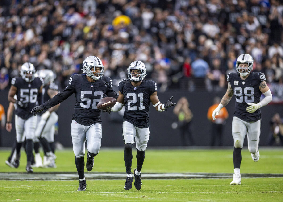 Vegas Raiders cornerback Amik Robertson (21) celebrates an interception with teammates against ...