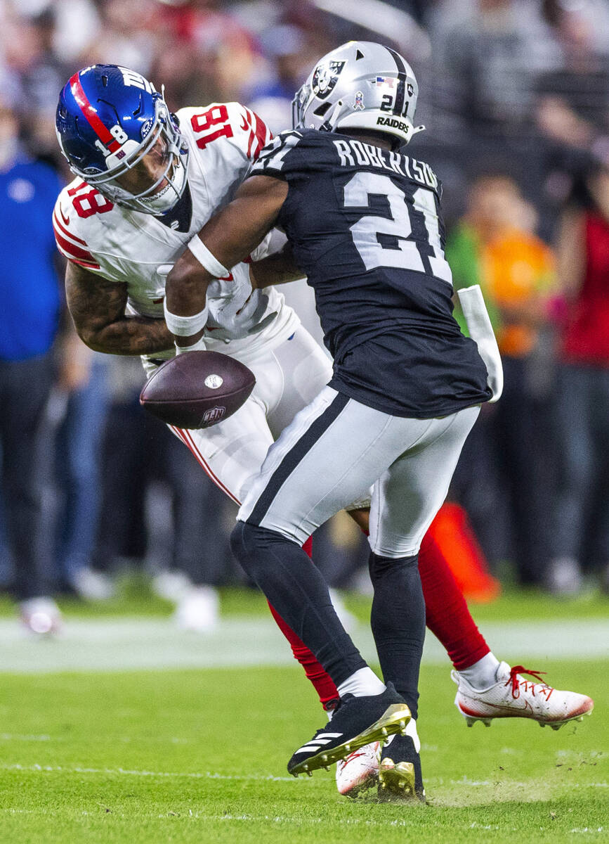 Vegas Raiders cornerback Amik Robertson (21) puts a big hit on New York Giants wide receiver Is ...