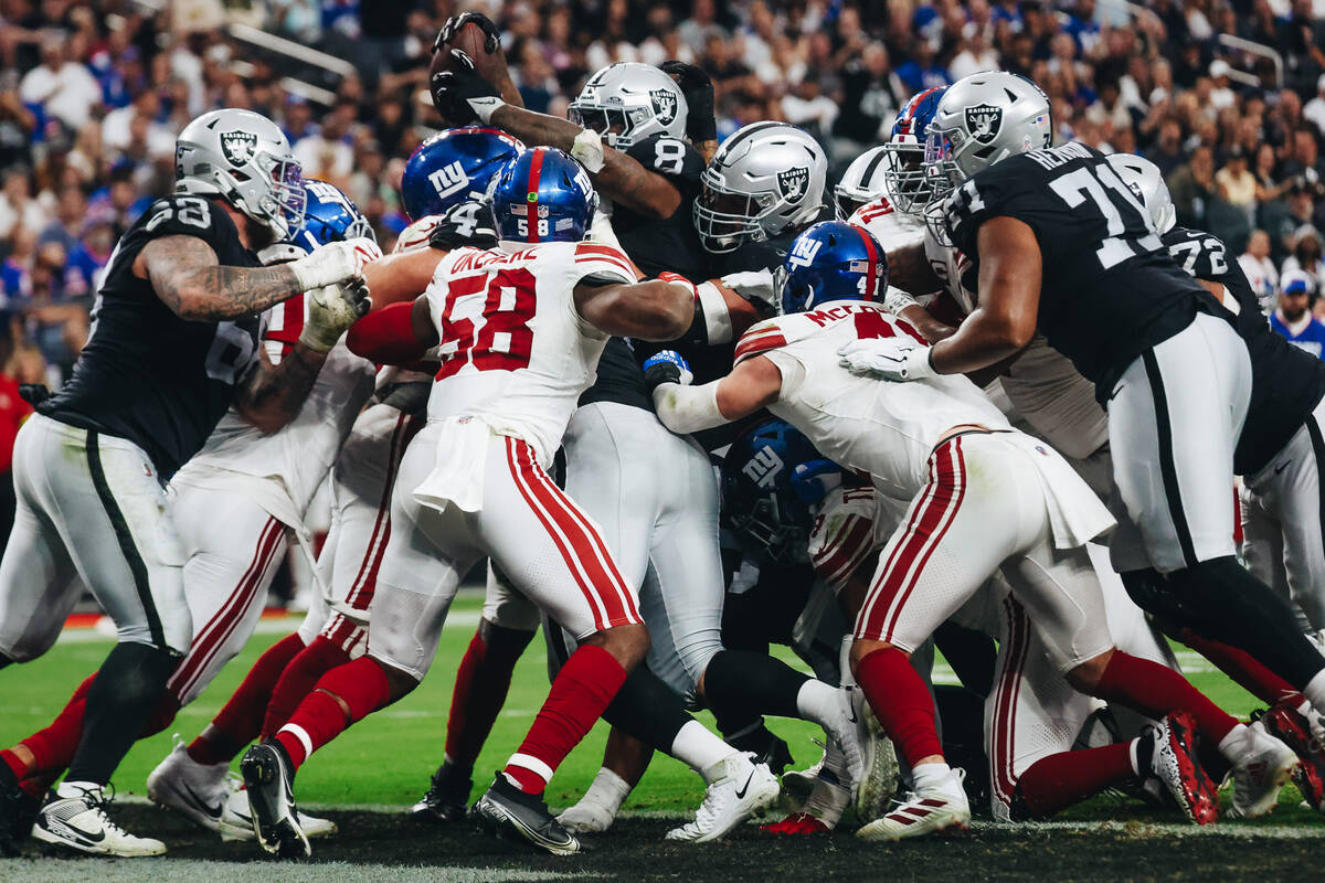 Raiders running back Josh Jacobs (8) fights to get the ball into the end zone for a touchdown d ...