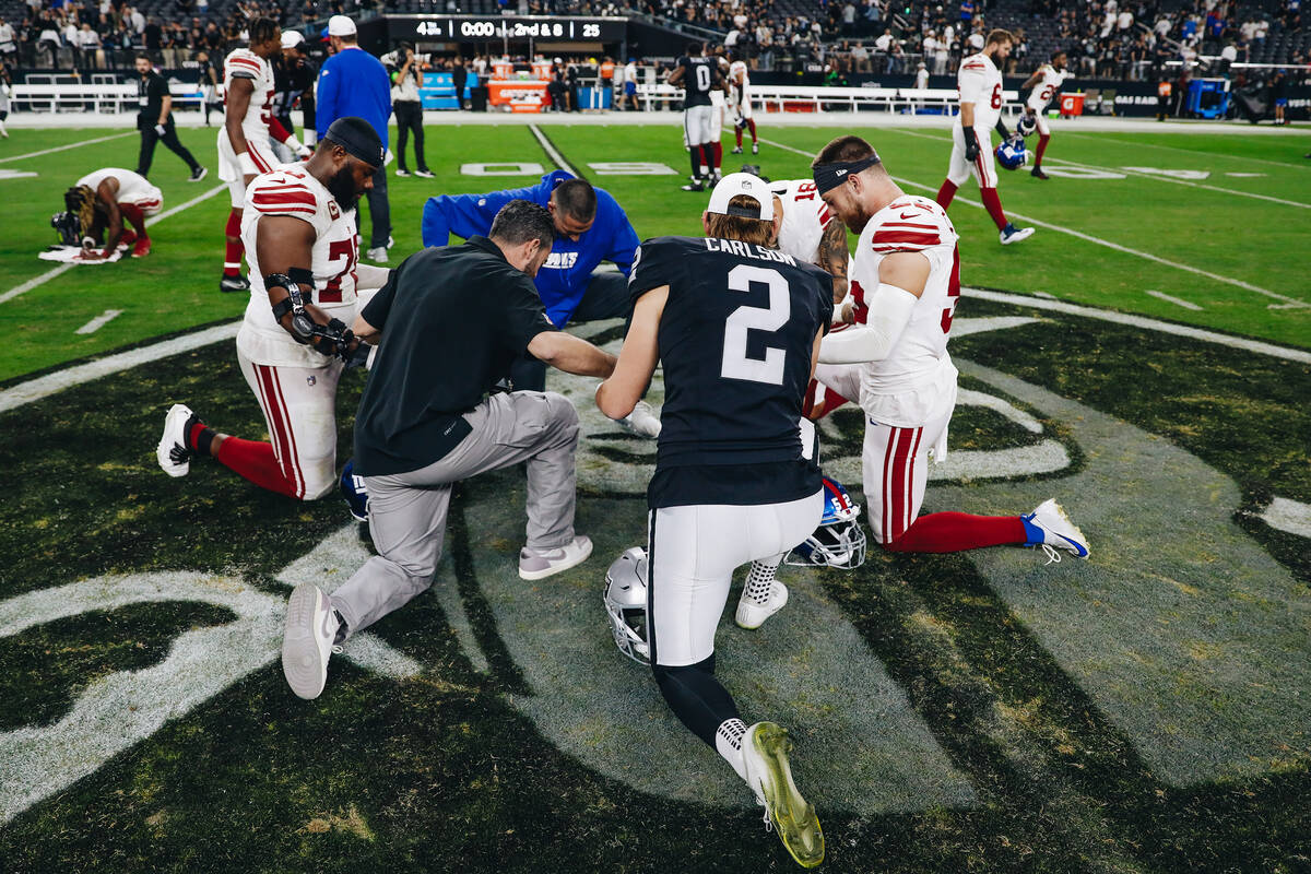 Raiders place kicker Daniel Carlson (2) prays with New York Giants players and coaching staff a ...