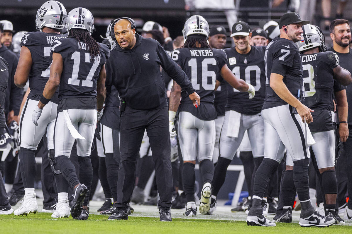 Raiders interim Head Coach Antonio Pierce chats with wide receiver Davante Adams (17) against t ...