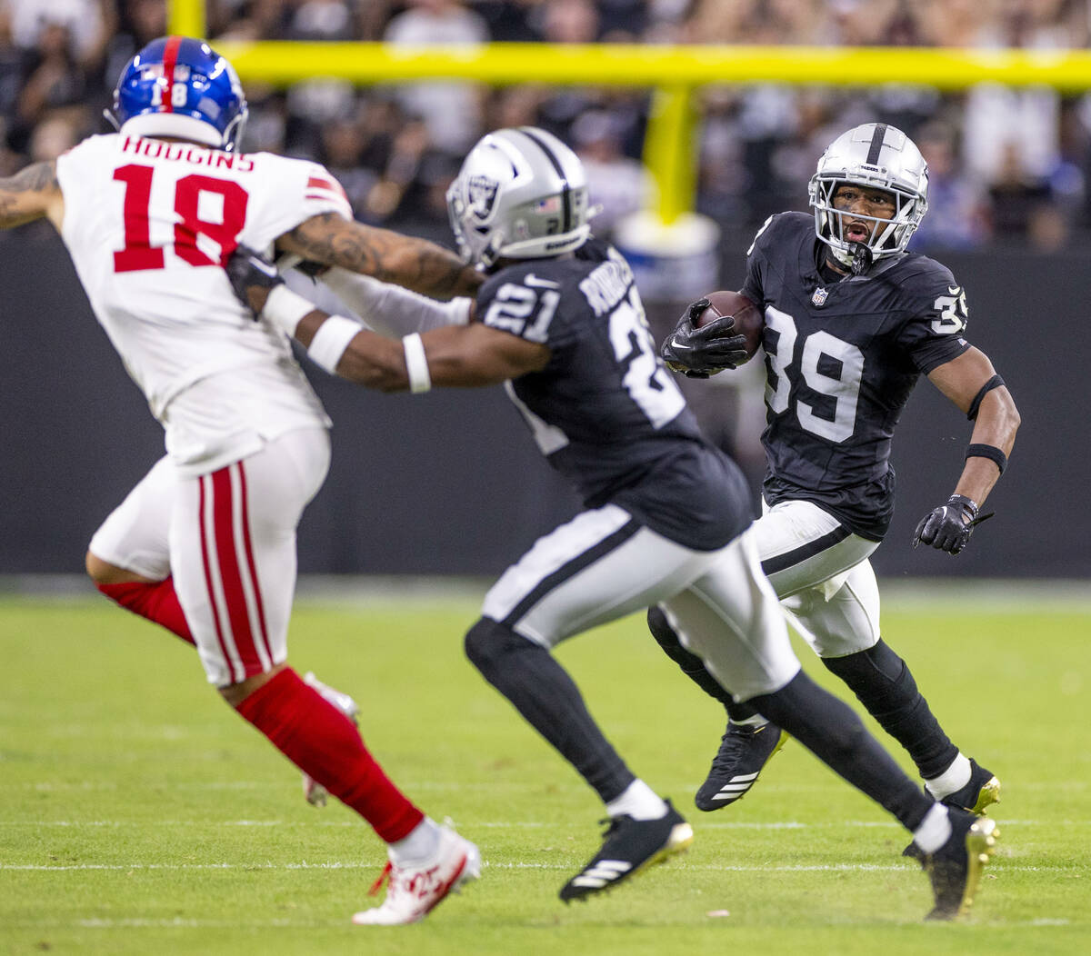 Raiders cornerback Nate Hobbs (39) looks for running room after an interception against the New ...
