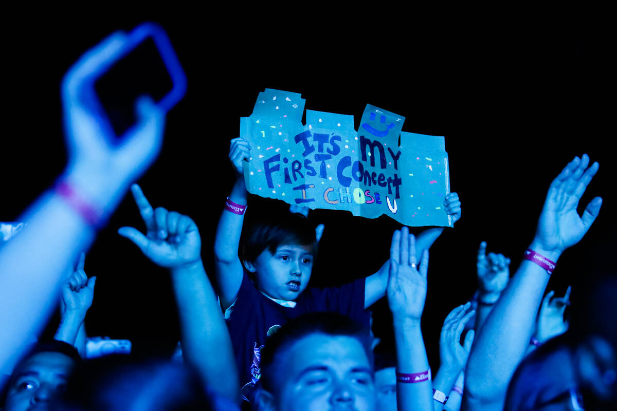 A kid holds up a sign during an AJR concert at the 2023 SEMA Fest on Saturday, Nov. 4, 2023 in ...