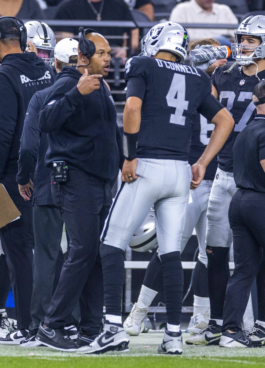 Raiders interim Head Coach Antonio Pierce speaks with quarterback Aidan O'Connell (4) during th ...