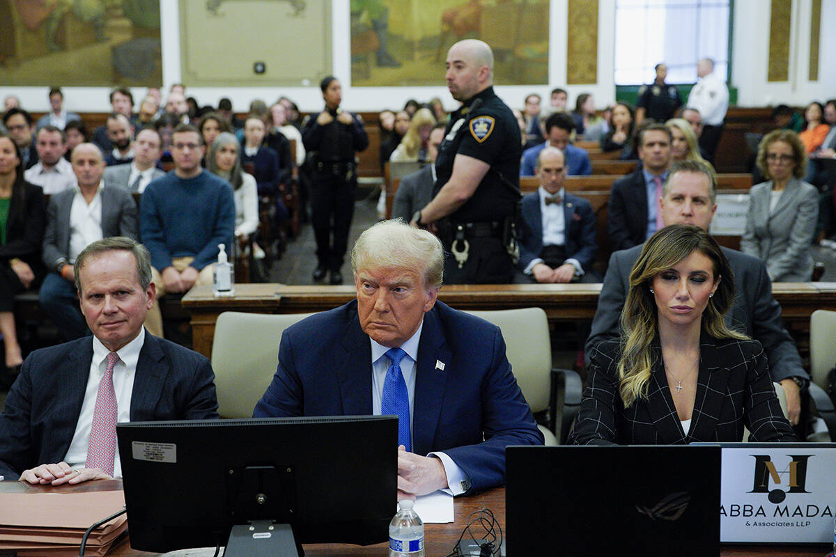 Flanked by his attorneys Chris Kise, left, and Alina Habba, former President Donald Trump waits ...