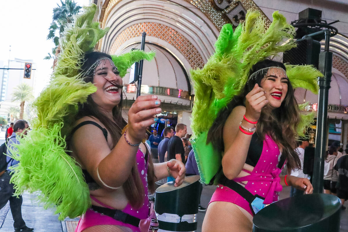 Showgirls battle through the wind along Fremont Street on Monday, Nov. 6, 2023 in Las Vegas. (D ...