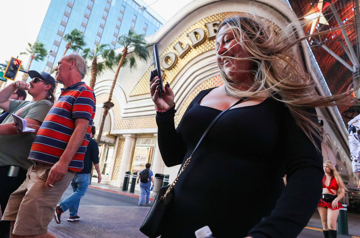 Tourists battle through the wind along Fremont Street on Monday, Nov. 6, 2023 in Las Vegas. (Da ...
