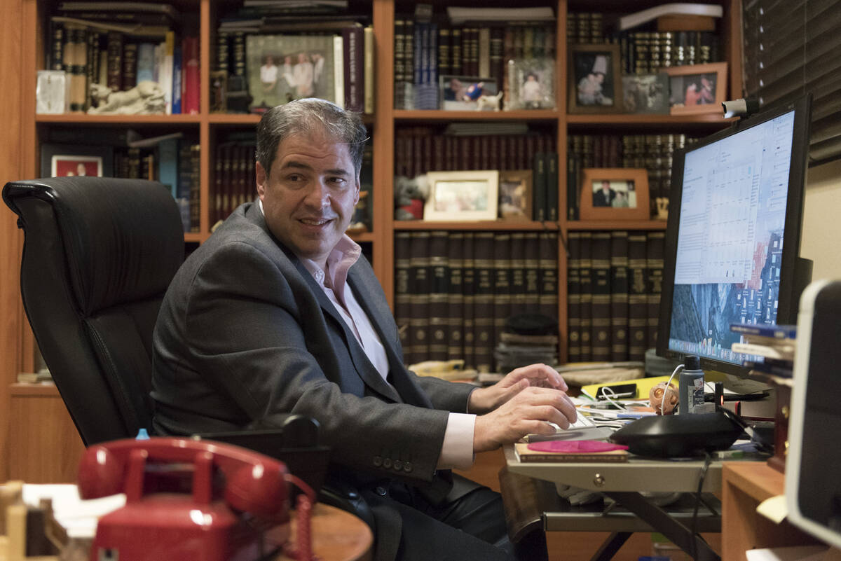 Rabbi Felipe Goodman works on his computer as he helps Allie Zacharia, 12, and Jacob Zacharia, ...