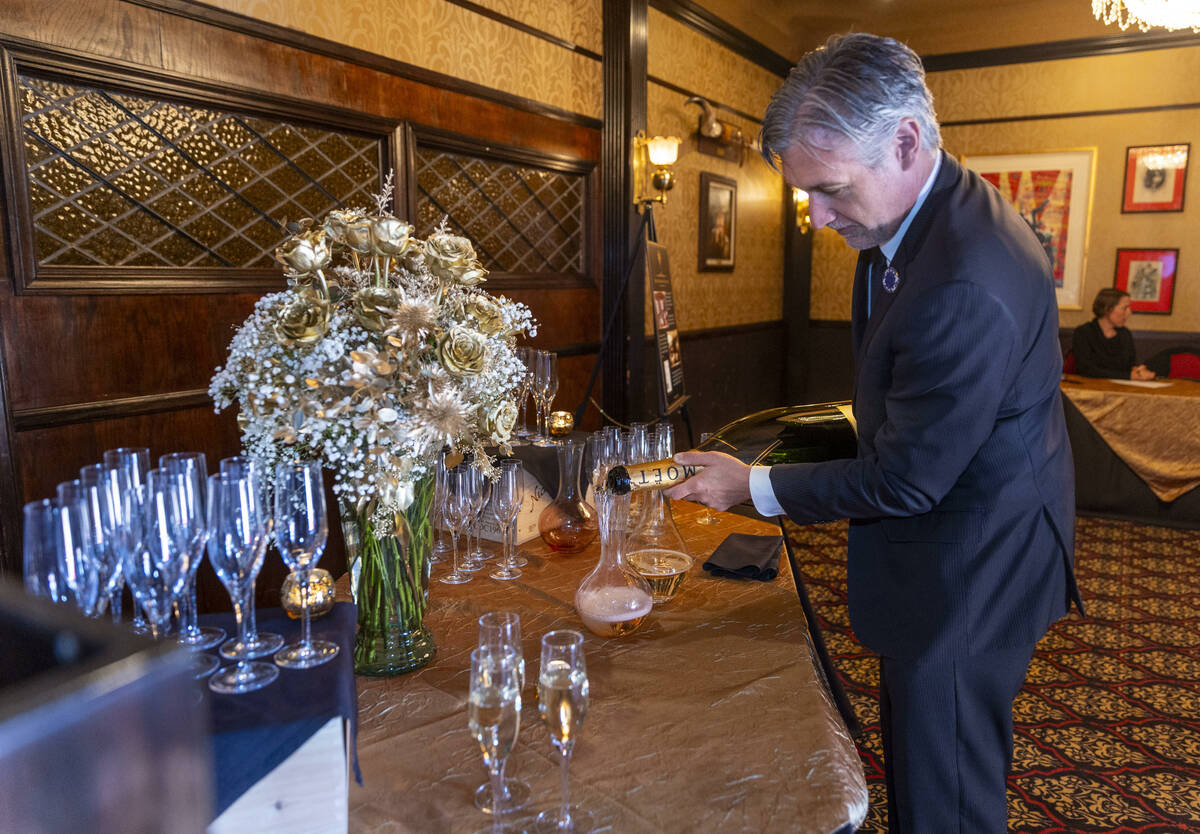 Rob Harpest pours champagne for guests during an event to celebrate the first expansion in near ...