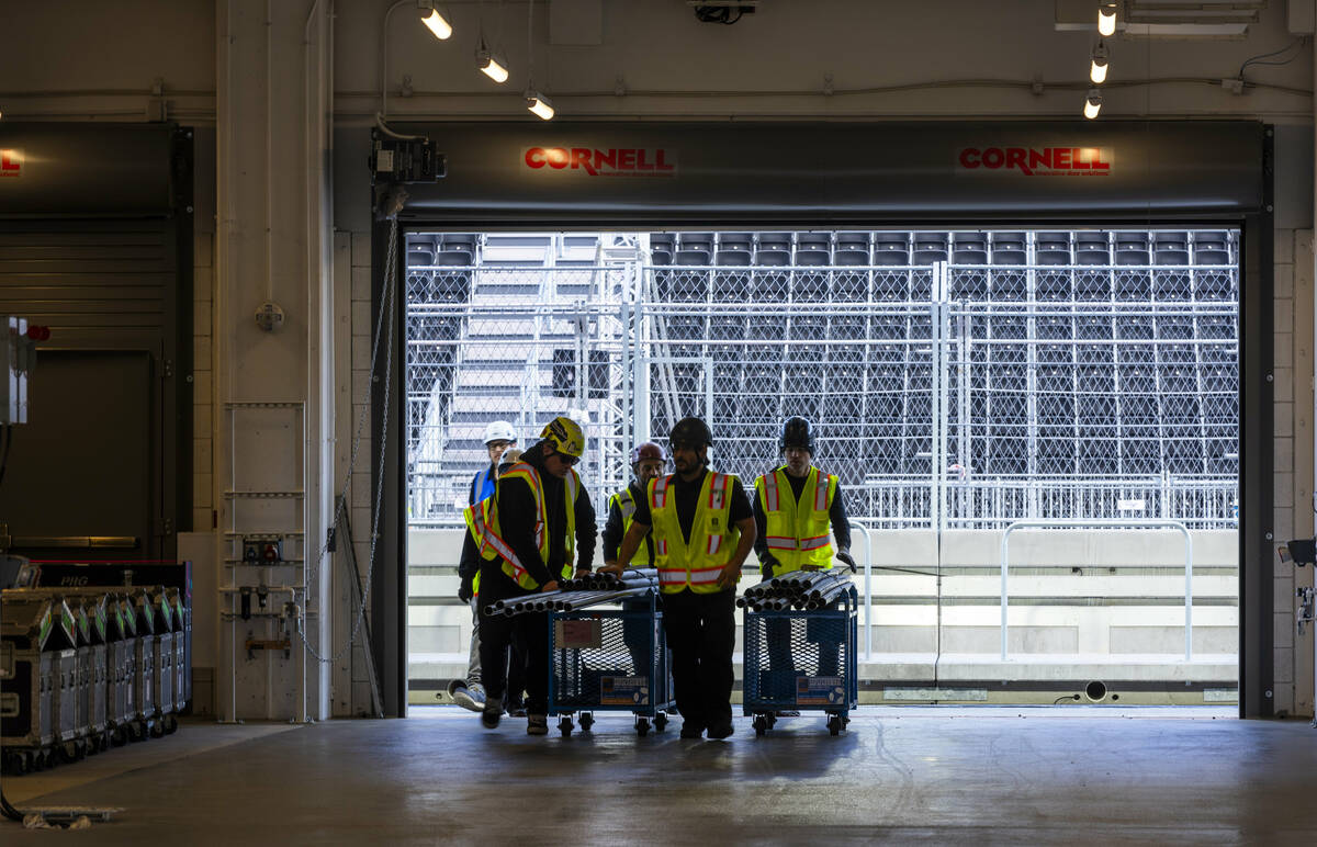 A construction crew moves materials through a team garage inside the Formula One Las Vegas Gran ...