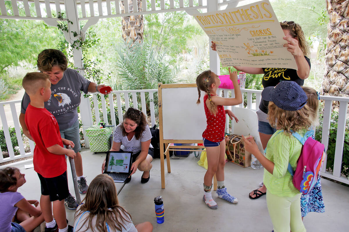Laura Runco holds a poster for botany lesson to a home-school group called Wise Owls at Springs ...