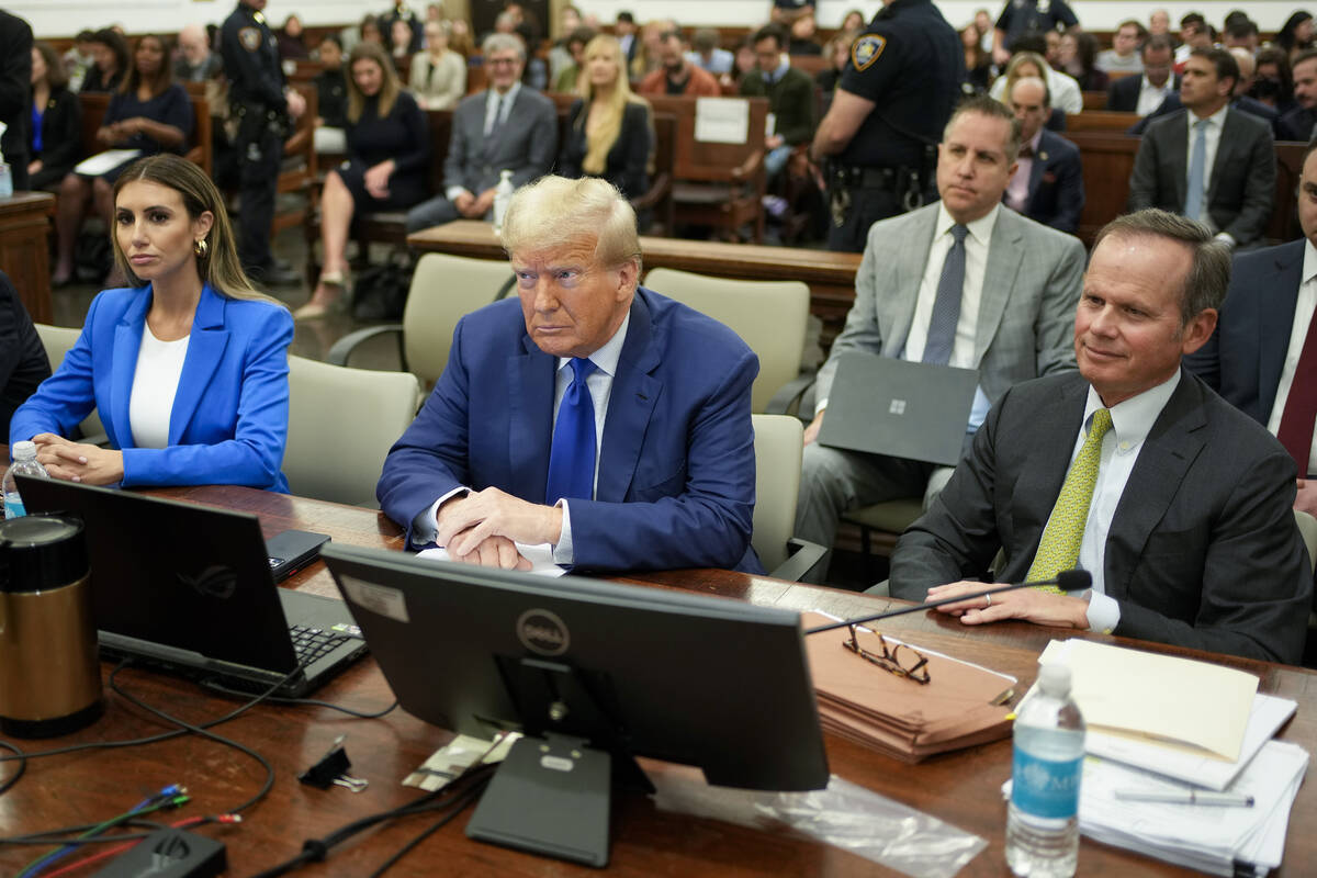 Former President Donald Trump, center, flanked by his defense attorneys, Alina Habba, left, and ...