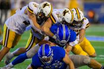 Wyoming defenders Easton Gibbs (28), Cole DeMarzo (25) and Wyett Ekeler (right) force a fumble ...