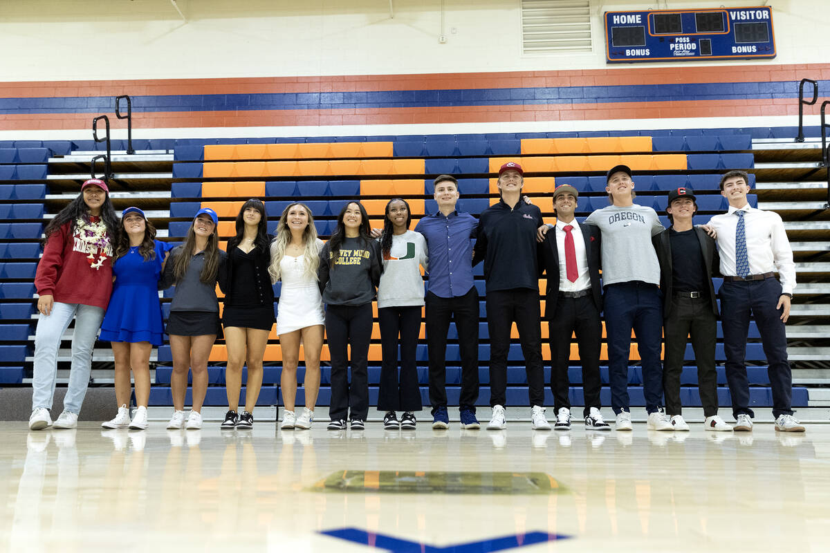 Several athletes pose for a photo after penning their national letter of intent to play college ...