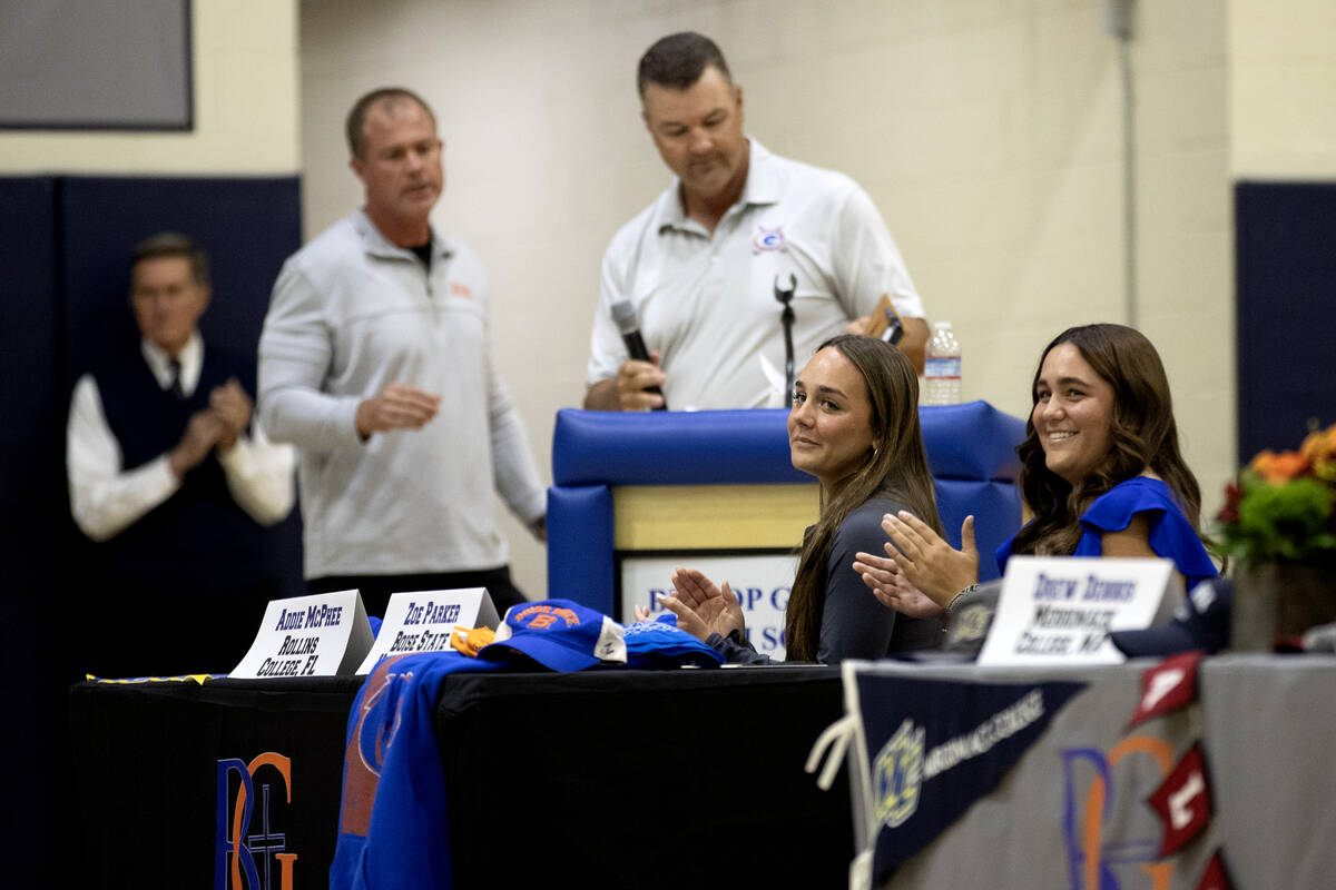 Lacrosse player Addie McPhee, left, and golfer Zoe Parker, right, clap before signing their nat ...